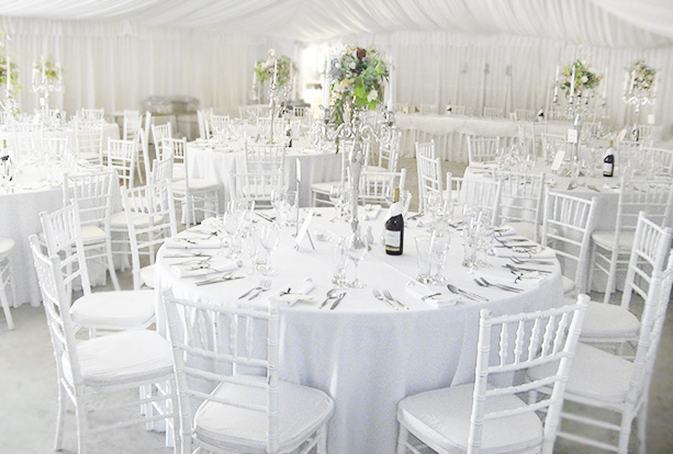 White wedding reception inside a marquee